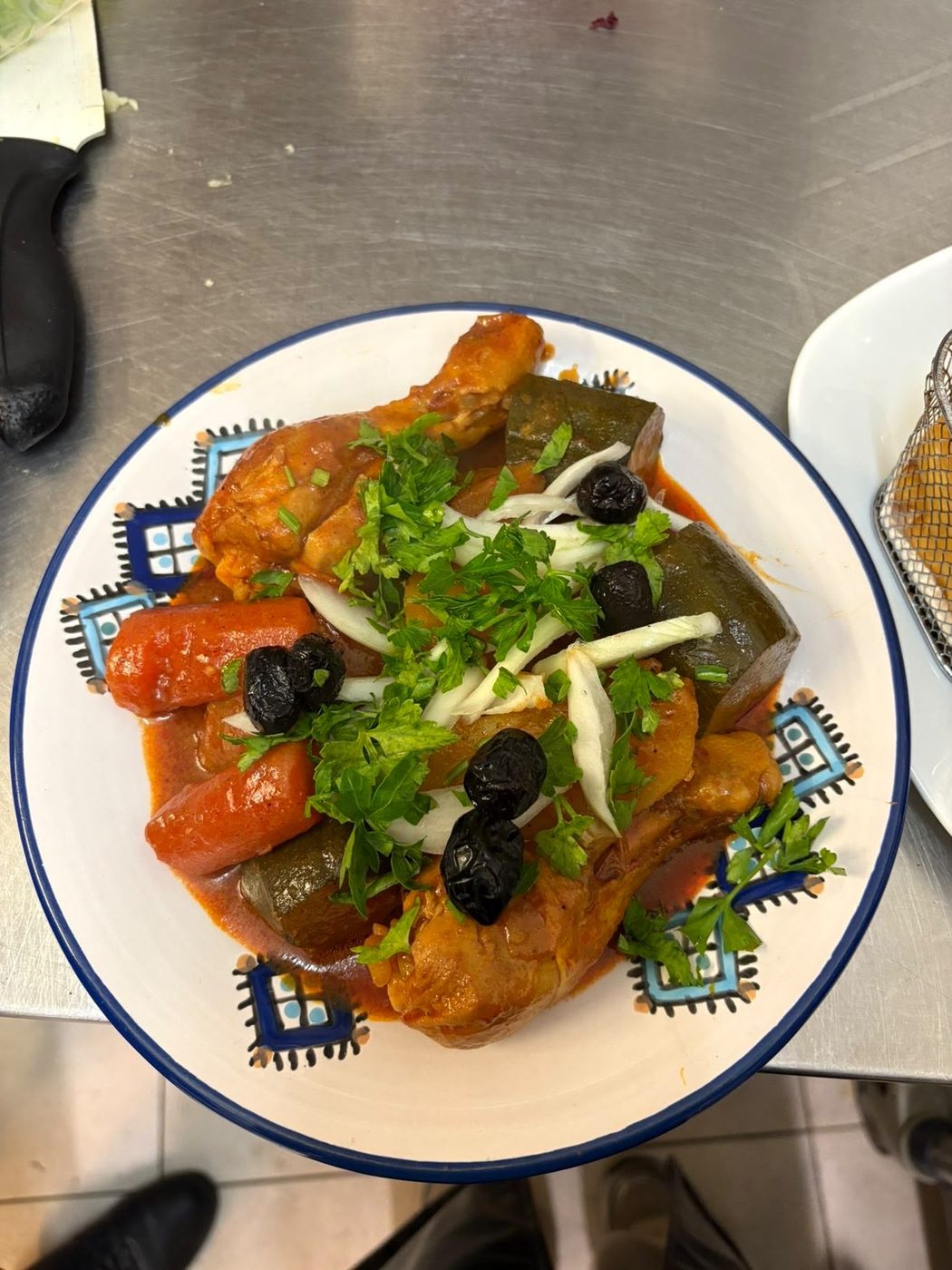Tajine de poulet aux carottes, courgettes et olives noires, parsemé de persil